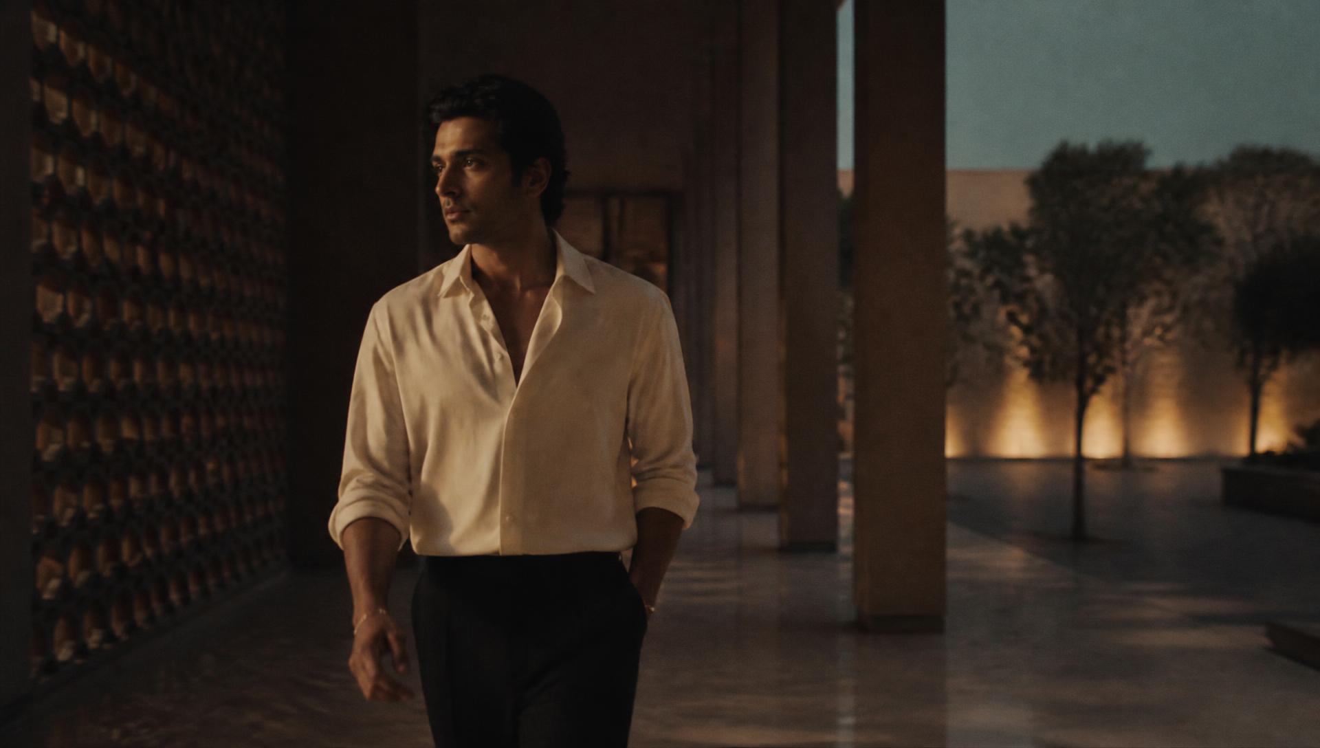 RYVORA campaign film: model walking a colonnade at dusk in ivory shirting